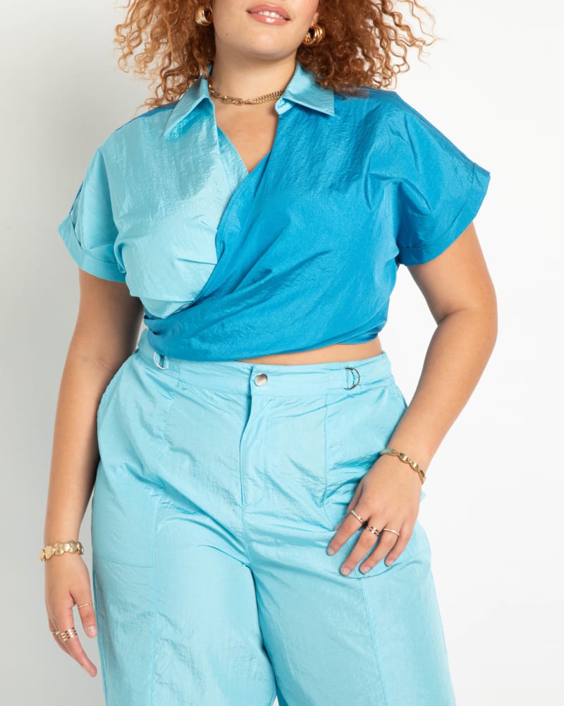 Front of a model wearing a size 22 Wrapover Collared Crop Top in Horizon Blue / Tropical Breeze by ELOQUII. | dia_product_style_image_id:283803